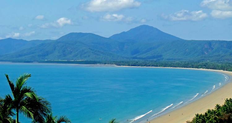 Scenic view of a beach with mountain background and clear skies.