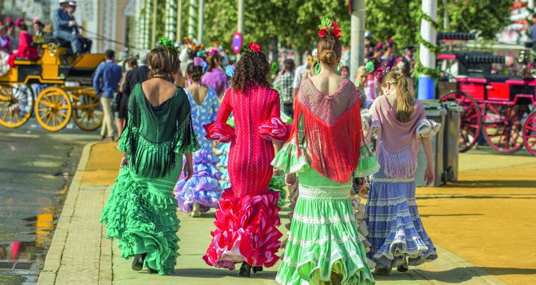 Frauen in bunten traditionellen Kleidern, die bei einer Veranstaltung gehen.