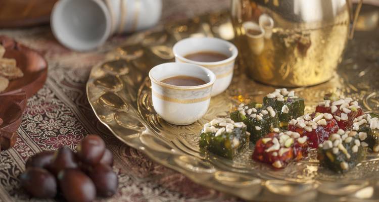 Traditionelle omanische Süßigkeiten und Kaffee auf einem dekorativen Tablett.