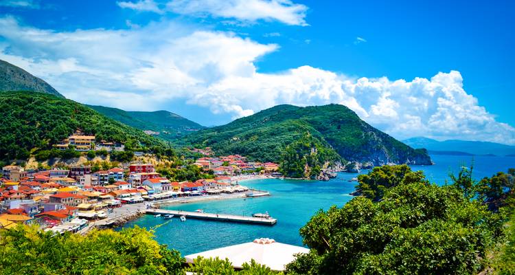 Farbenfrohe Küstenstadt Parga, eingebettet zwischen grünen Hügeln und dem türkisfarbenen Ionischen Meer.