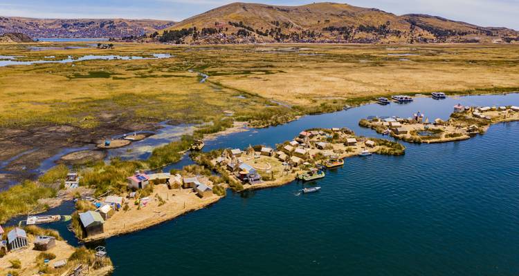 Vue aérienne des îles flottantes d'Uros en roseaux parsemées sur les eaux bleu profond du lac Titicaca.
