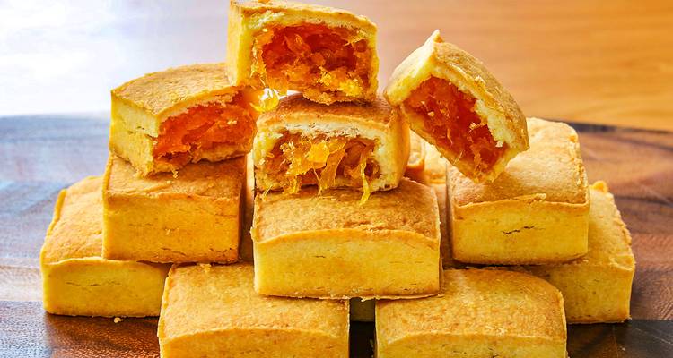 Anananskuchenstücke gestapelt auf einer Holzoberfläche.