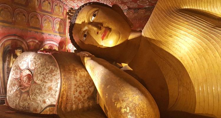 Grote liggende Boeddhabeeldje in een tempel.