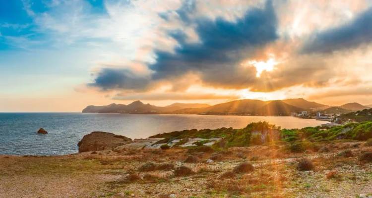 Dramatische zonsondergang over de ruige Middellandse Zeekust en verre bergen op Mallorca