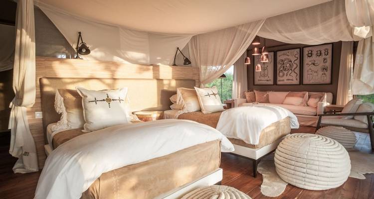 Luxuriöses Schlafzimmer mit eleganter Einrichtung und einer Sitzecke.