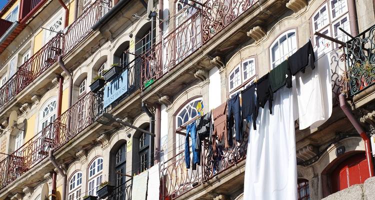 Una vista de cerca de la fachada de un edificio con balcones y ropa colgada para secar.