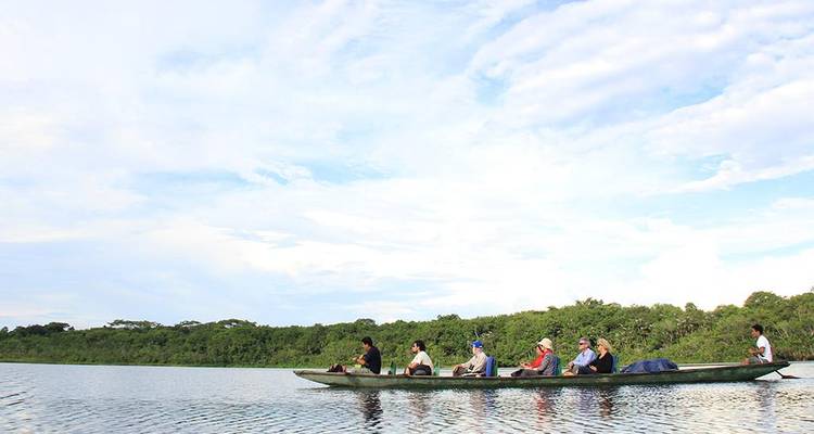 Un grupo de personas en una canoa sobre un gran cuerpo de agua.