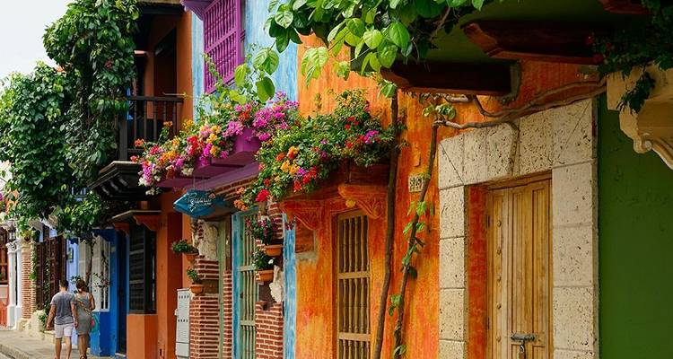 Levendige met bloemen volgeladen balkons en kleurrijke stucco gevels sieren een schilderachtig straatje in Cartagena.