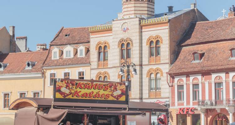 Historischer Platz mit traditionellen Gebäuden und Imbissstand.
