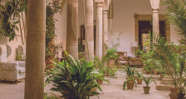 Cour intérieure avec colonnes en pierre et verdure.