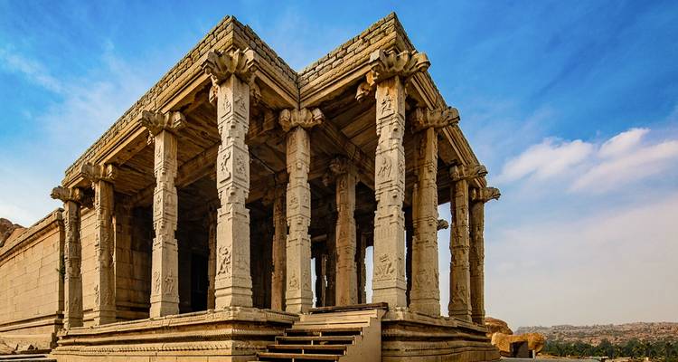 Steinpavillon mit detaillierten Schnitzereien in einem felsigen Gebiet.
