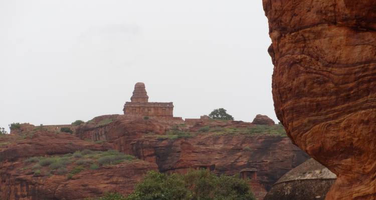 Tempel auf einem felsigen Hügel mit Vegetation ringsum.