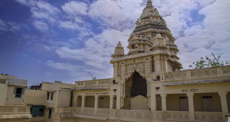 Bâtiment de temple orné sous un ciel partiellement nuageux.