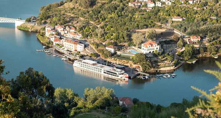 Bateau de croisière amarré dans un village pittoresque au bord de la rivière.