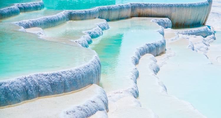 Primer plano de terrazas termales naturales con agua azul.