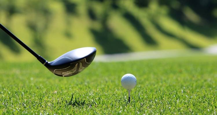 Pelota de golf en un tee con un driver preparándose para golpear
