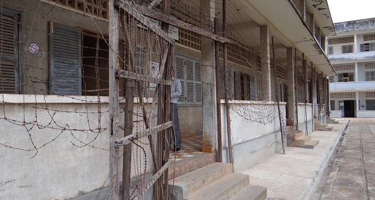 Barbed-wire enshrouded corridors of the former S-21 prison evoke stark history.