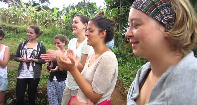 Groep deelnemers die klappen en glimlachen tijdens een buitenactiviteit.