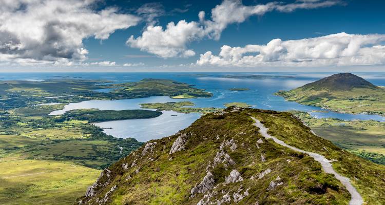 Bergkammwanderweg mit Ausblick auf Seen, Inseln und den Atlantischen Horizont im Connemara-Nationalpark.