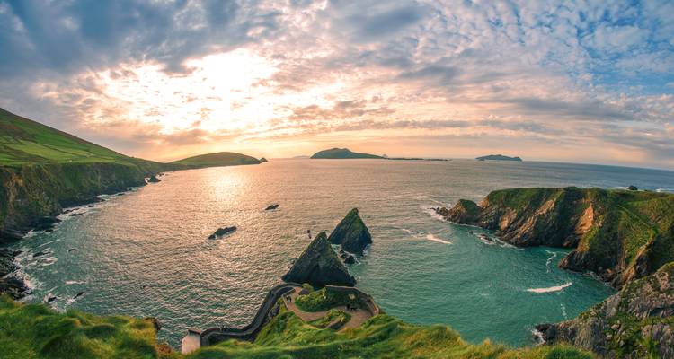 Dramatische Küstenklippen und türkisfarbene Bucht bei Sonnenuntergang auf der Dingle-Halbinsel, Irland.