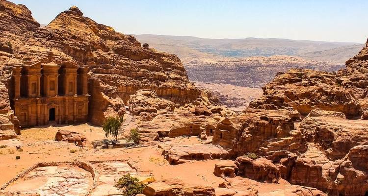 Antike in Fels gehauene Struktur in einer weiten Wüstenlandschaft.