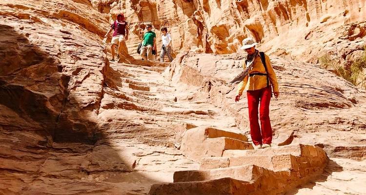 Gruppe von Menschen, die Steinstufen in einer Schlucht hinabsteigen.