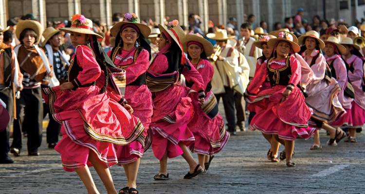 Festival mit Frauen in traditionellen bunten Kleidern, die tanzen.