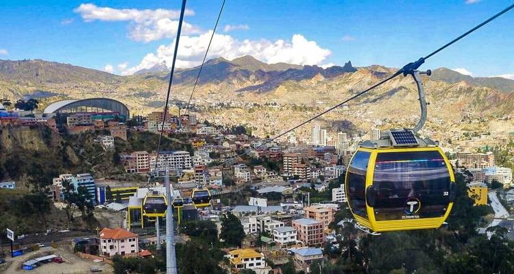 Kabelbanen over een bergachtig stedelijk landschap.