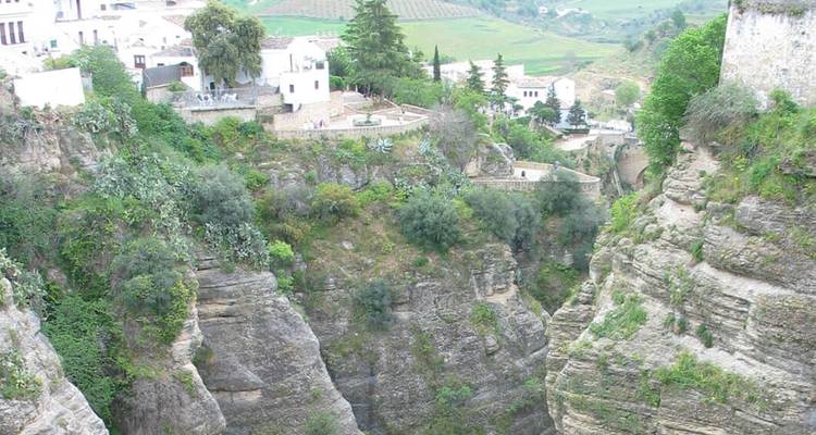 Une gorge rocheuse spectaculaire avec des bâtiments perchés au bord.