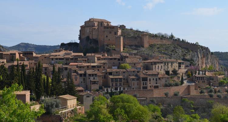 Une ville avec une architecture historique sur une colline sous un ciel bleu.