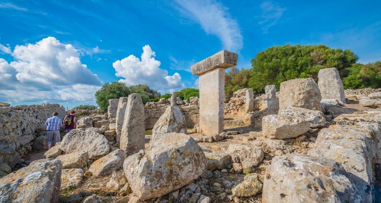 Anciennes structures de pierre avec ciel bleu et visiteurs.
