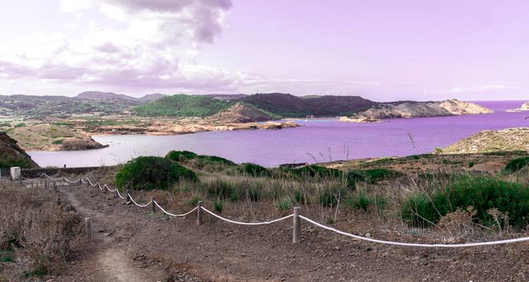 Sentier le long de la côte avec un ciel teinté de violet.