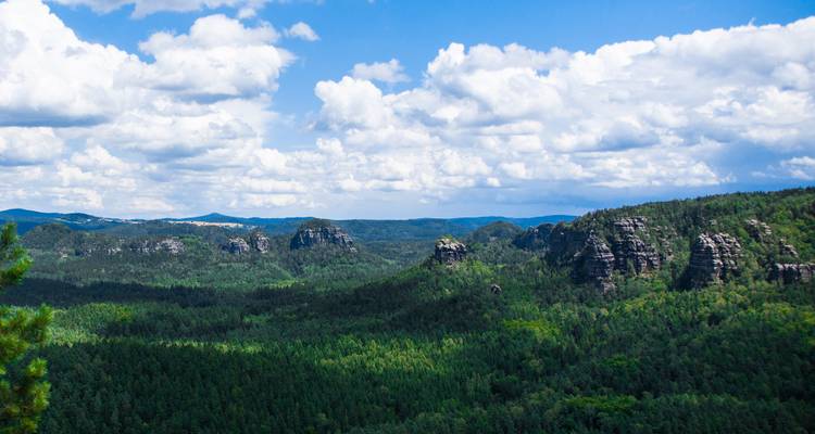Vue de collines boisées avec des formations rocheuses au loin.