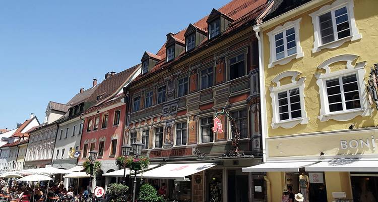 Des bâtiments historiques colorés bordant une rue animée.