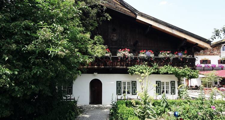Traditioneel alpenhuisje omgeven door groen.