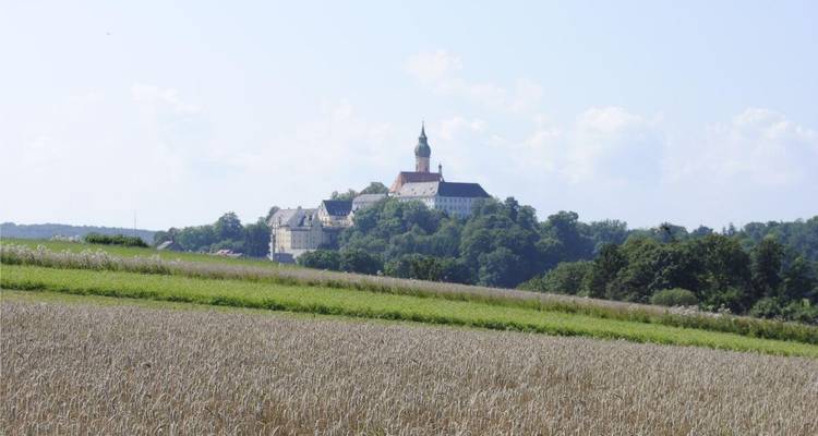 Château vu de loin avec des champs au premier plan.