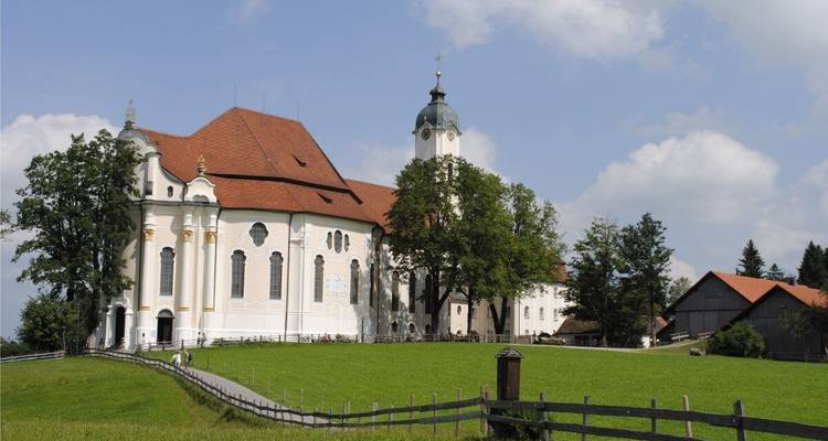 Église avec un grand dôme sur une colline herbeuse.