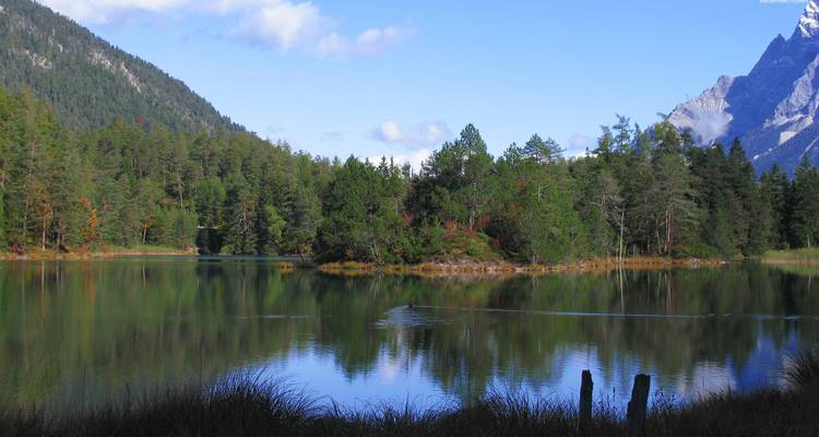 Serene meer omgeven door bomen en bergen.