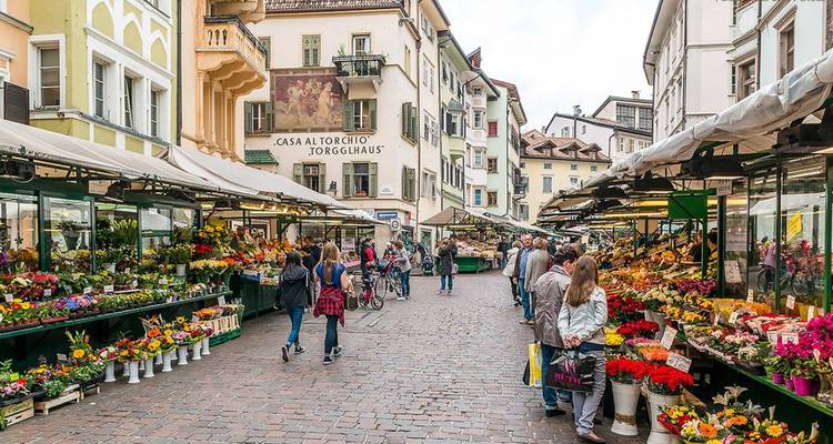 Drukke marktstraat met bloemenstalletjes en mensen