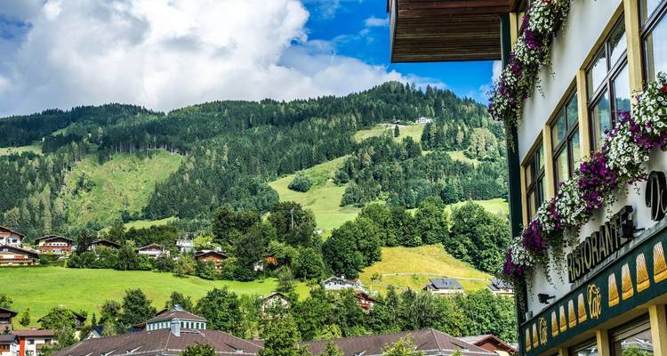 Dorf mit blumengeschmückter Architektur und grünen Hügeln
