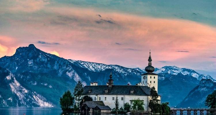 Un élégant bâtiment avec un décor de montagne au coucher du soleil.