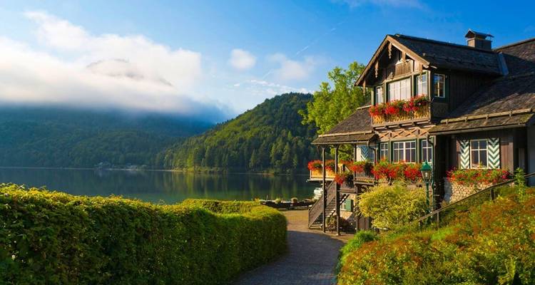 Une charmante maison au bord du lac avec un sentier de jardin.