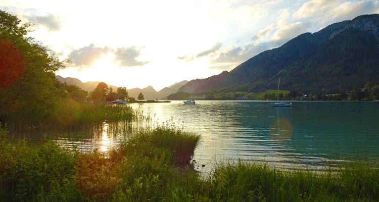 Sunset view over a lake with hills in the background.