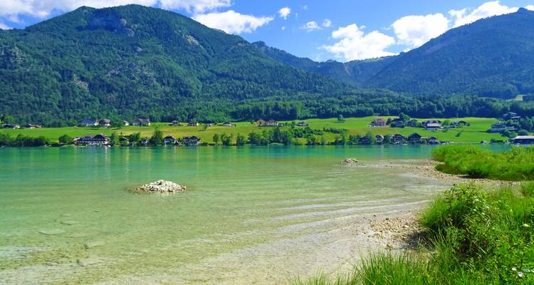 Clear lake with a mountain view and greenery.
