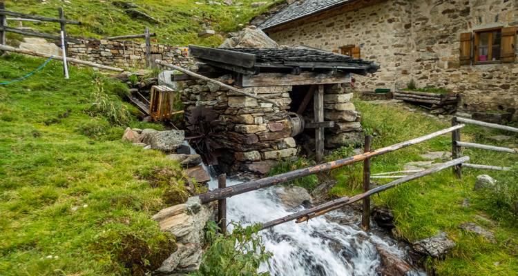 Vieux moulin avec un cours d'eau qui coule à proximité.