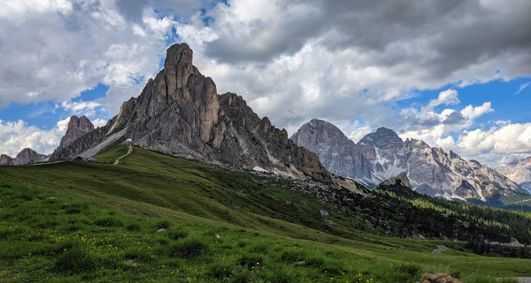 Pic rocheux se dressant fièrement contre le ciel bleu et les nuages.
