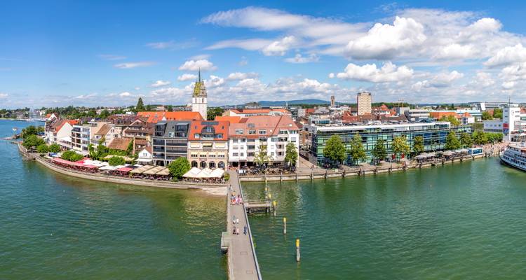 Panoramablick auf eine Seestadt mit Gebäuden und Booten.