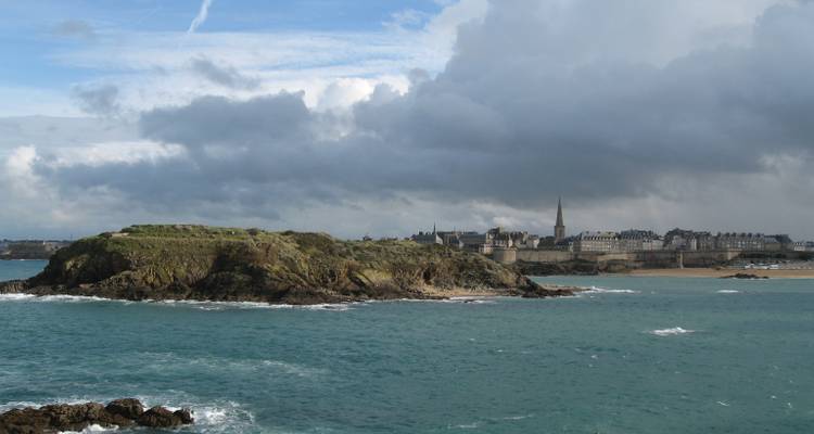View of Saint-Malo from across the bay under a cloudy sky.