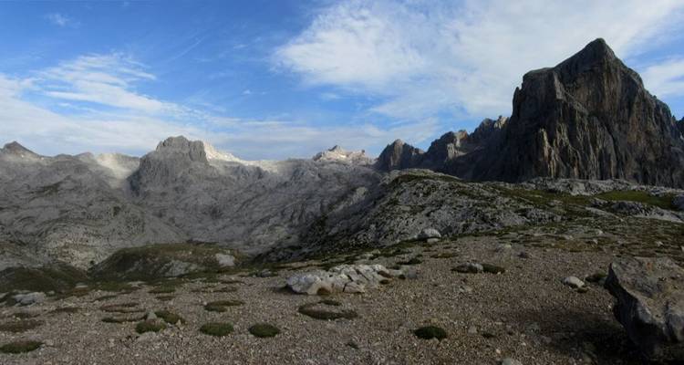Vue étendue de pics montagneux escarpés sous un ciel bleu.