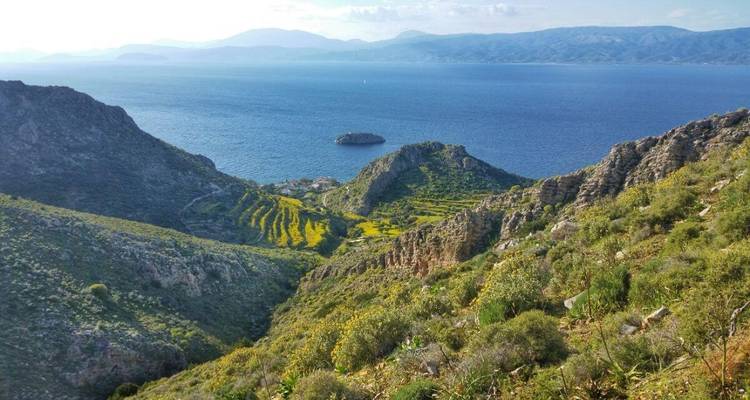Un paysage côtier avec des terrasses et une petite île dans la mer.